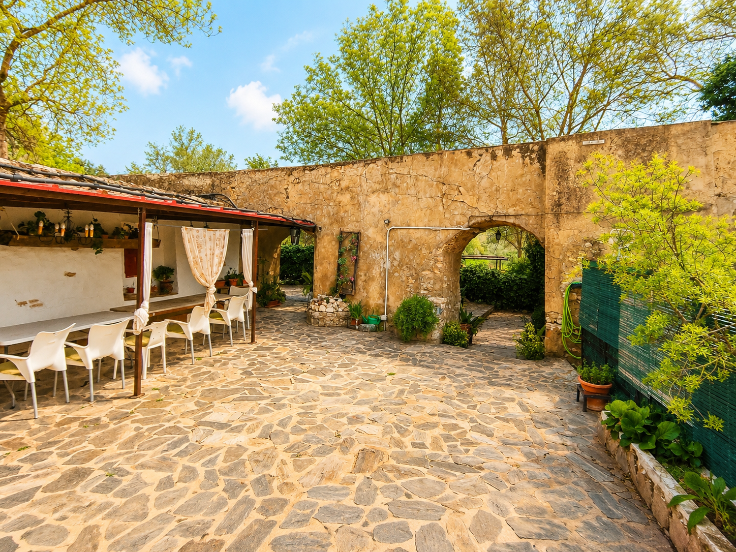 Patio de piedra y arcos del cortijo